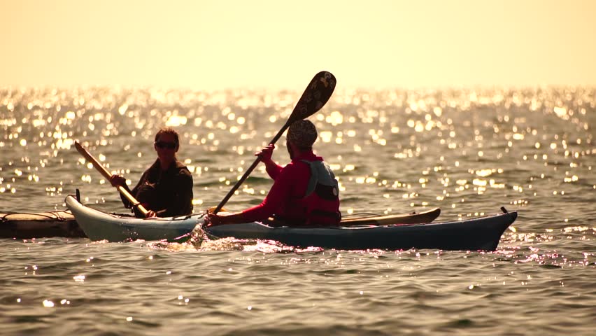 Woman sea kayak. Happy smiling woman in kayak on ocean, paddling with wooden oar. Calm sea water and horizon in background. Active lifestyle at sea. Summer vacation. Royalty-Free Stock Footage #3453721813