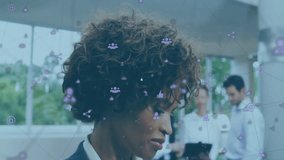 Animation of network of connections with icons over african american businesswoman using smartphone. Global business, connections and digital interface concept digitally generated video.