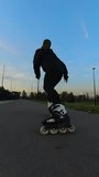 Caucasian woman roller skating in the evening. Slalom. Vertical video. 