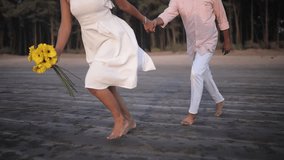 Experience the joy of love as a couple runs hand in hand along the beach, the sunset painting the sky. The girl holds a sunflower, symbolizing beauty and happiness in their embrace. - Powered by Shutterstock - Get 15% off with code: PIKWIZARD15