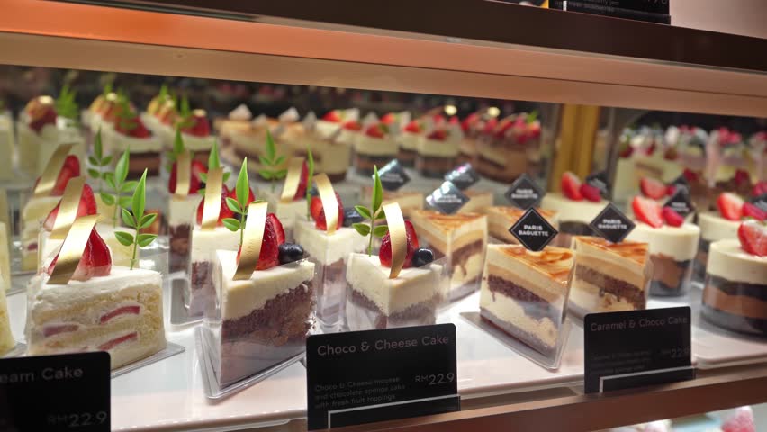 Various types of cakes displayed on the shelf and selling in the bakery shop.