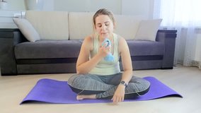 Slow motion video of exhausted young woman with towel after workout at home
