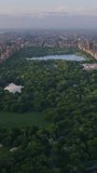 Vertical Screen: New York Cityscape at Sunset. Aerial Footage from a Helicopter. Modern Skyscrapers Around Central Park in Manhattan Island. Focus on Nature, Trees and Lakes in the Park in the City