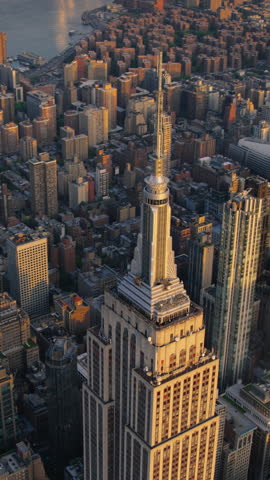 Vertical Screen: Sunset Aerial View of xxxx Spire and a Top Deck Tourist Observatory. New York City Business Center From Above. Helicopter Footage of Midtown Manhattan