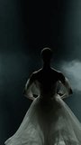 Ballet, vertical video, graceful ballerina in a white tutu dance and perform choreographic elements on a black background, dramatic dance.