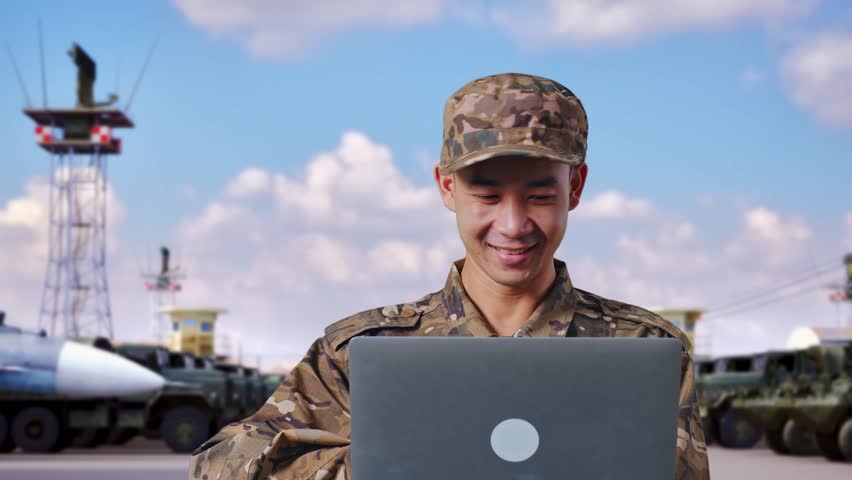 Close Up Of Asian Man Soldier Using A Laptop And Pointing To Side While Standing At Military Camp