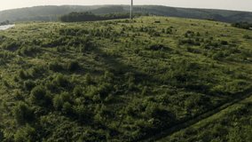 Ascending Drone View of a Wind Turbine on Green Fields