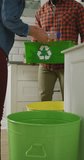 Vertical video of diverse couple segregating waste at home. family spending time together at home and body inclusivity.