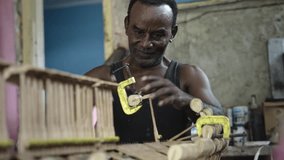 African American luthier repairing old wooden piano keyboard - Powered by Shutterstock - Get 15% off with code: PIKWIZARD15