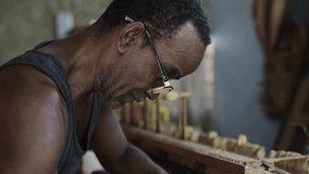 Cuban traditional artisan working on wooden musical instrument, repairing old piano keyboard - Powered by Shutterstock - Get 15% off with code: PIKWIZARD15