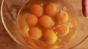 close-up shots of mixing a large quantity of eggs in a big glass bowl