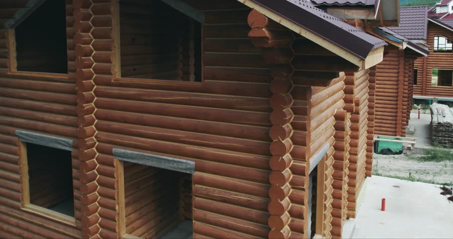 Construction site of wooden mountain house. Traditional log cabin built from wood logs on sunny summer day. Cottage house design, aerial view