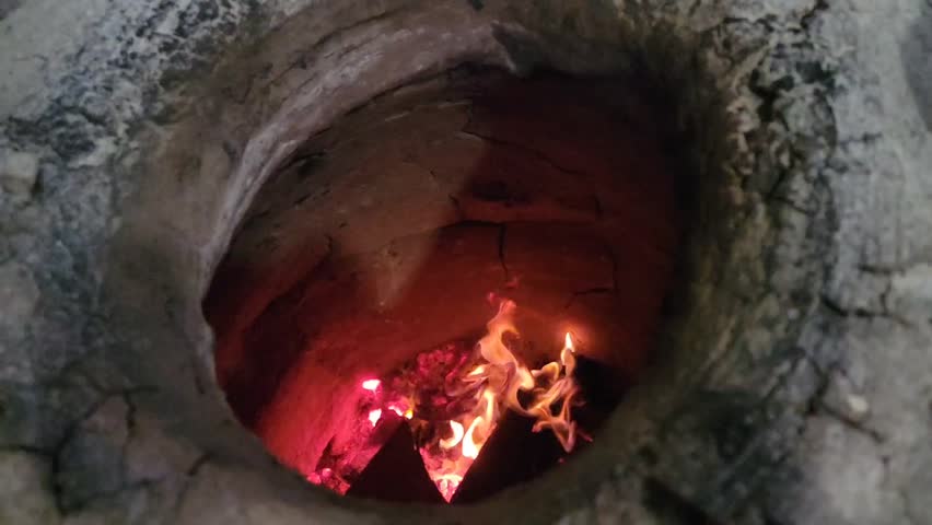 Kindling firewood in the tandoor. Preparing the tandoor for baking bread. Barbecue outdoors. Slow motion video. Burning wood inside tandoor. Slow Motion Video Royalty-Free Stock Footage #3454160705