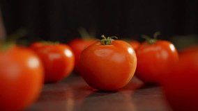 A slow-motion video of a tomato rotating on a table among others. Salad preparation, healthy eating, vegetarianism. High quality FullHD footage