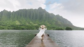 Back view of tourist walking at epic landscapes on Oahu island. Camera following woman exploring secret beach pond on Hawaii island. Aerial wooden pier with cinematic Jurassic nature mountain views 4K - Powered by Shutterstock - Get 15% off with code: PIKWIZARD15