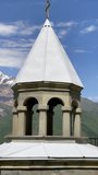 4K vertical videp of Kazbek 5054m mountain view with architectural arches of the chapel in Prophet Elijah Fathers Monastery on the green grass hill near Stepantsminda, East Caucasus, Georgia