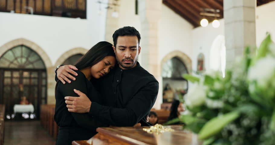Death, loss or couple at funeral by coffin, mourning or man to comfort woman for dead family. Grief, support and people grieving together by wooden casket and sadness at remembrance service in church