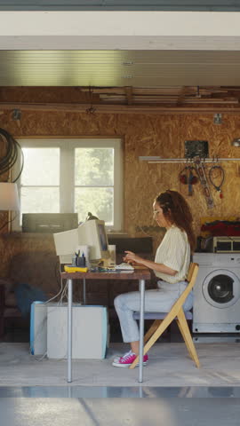 Vertical Screen: Hispanic Female Developer Programming On Old Desktop Computer In Retro Garage With Random Appliances. Young Woman Working On Innovative Online Service Startup Company In Nineties.