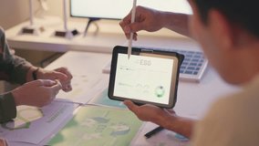 Business team examines ESG performance metrics on a tablet during a sustainability strategy session in a modern office. - Powered by Shutterstock - Get 15% off with code: PIKWIZARD15