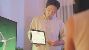 An Asian businessman gives a presentation on renewable energy, holding a solar panel during an indoor corporate meeting. - Powered by Shutterstock - Get 15% off with code: PIKWIZARD15