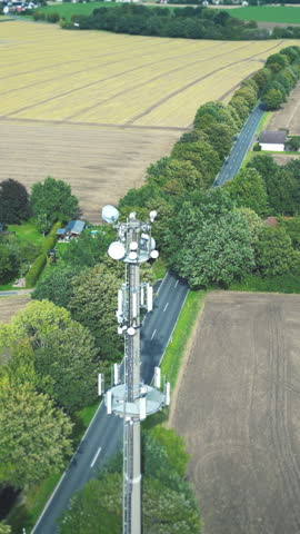 Communications tower sends individual network lines of data and 5G, 6G connections to access points in rural landscape, vertical Royalty-Free Stock Footage #3454521749