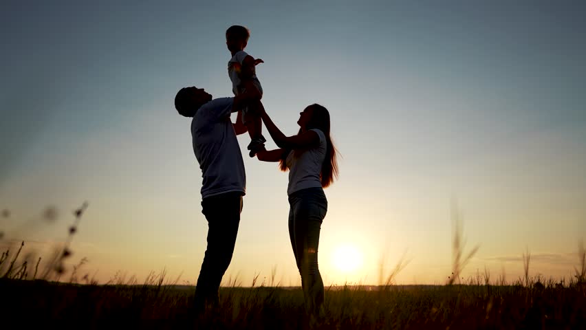 family standing on field. happy childhood concept for little child. big happy family stands on field, parents raised the child in their arms, lifestyle sunset on the background, silhouettes Royalty-Free Stock Footage #3454605465