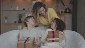 Mom makes gift for little daughter and son, gives box congratulates birthday. Preschool girl and boy cover eyes with hands anticipate mommy surprise. twins brother and sister birthday  - Powered by Shutterstock - Get 15% off with code: PIKWIZARD15