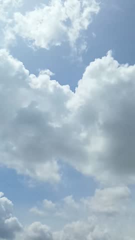 Bright white clouds fly across the bright blue sky. The sky is clear in the afternoon. Background view of clouds moving in the wind. Copy space
