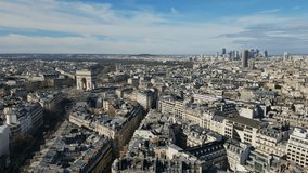 Drone descending over roofs of Paris with Triumphal arch or Arc de Triomphe in background, France. Aerial view and sky for copy space