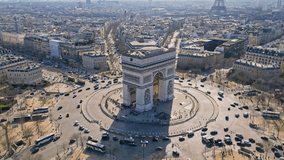 Triumphal arch and car traffic on roundabout, Paris cityscape, France. Aerial orbiting