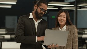 Two multiracial business people multiethnic diverse colleagues co-workers Asian woman Chinese businesswoman talk Indian man Arabian businessman together discuss project looking at laptop in office - Powered by Shutterstock - Get 15% off with code: PIKWIZARD15