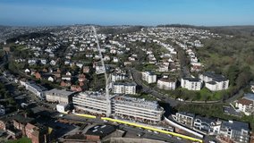 Torquay, Torbay, South Devon, England: DRONE VIEWS: The drone circles a new hotel construction site and its crane, close to the seafront. Torquay is a popular UK holiday resort (Clip 4).