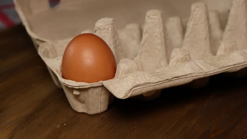 A hand picks up a hen's egg from an empty recyclable egg carton Royalty-Free Stock Footage #3454785941