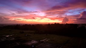 Hyperlapse timelapse of colorful sky at sunset over Indonesian Ubud village, Bali. Aerial forward. Day to night