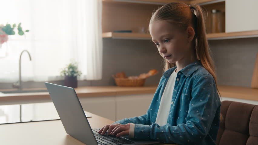 Caucasian alone child girl communication in social media online with computer at home kitchen using laptop typing browsing playing game kid daughter studying internet education use pc technology Royalty-Free Stock Footage #3454816517
