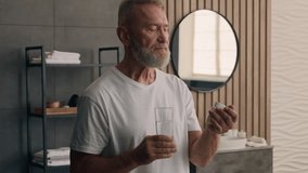 Unhealthy retired old Caucasian man senior mature male grandpa health care healthy drinking vitamins morning habit at home drink pill remedy medicine drug supplement water smiling at camera toothy - Powered by Shutterstock - Get 15% off with code: PIKWIZARD15