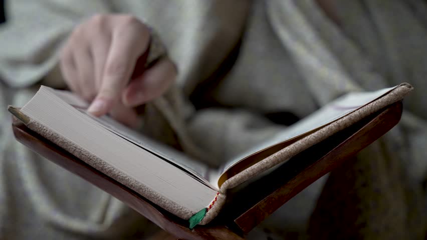 Close Up Of Finger Reading And Tracing Lines From Religious Book, symbolizing the pursuit of home-based studying and learning. Low Angle, Static Shot Royalty-Free Stock Footage #3454830563