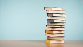 Stop Motion of colorful old books being moved from a stack to a row and back again on a wooden table - Powered by Shutterstock - Get 15% off with code: PIKWIZARD15