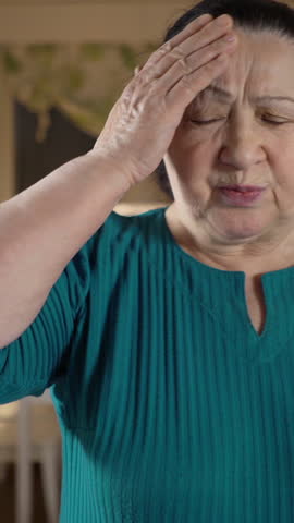 Old woman suffers from a headache and takes pills. Healthcare old people concept.