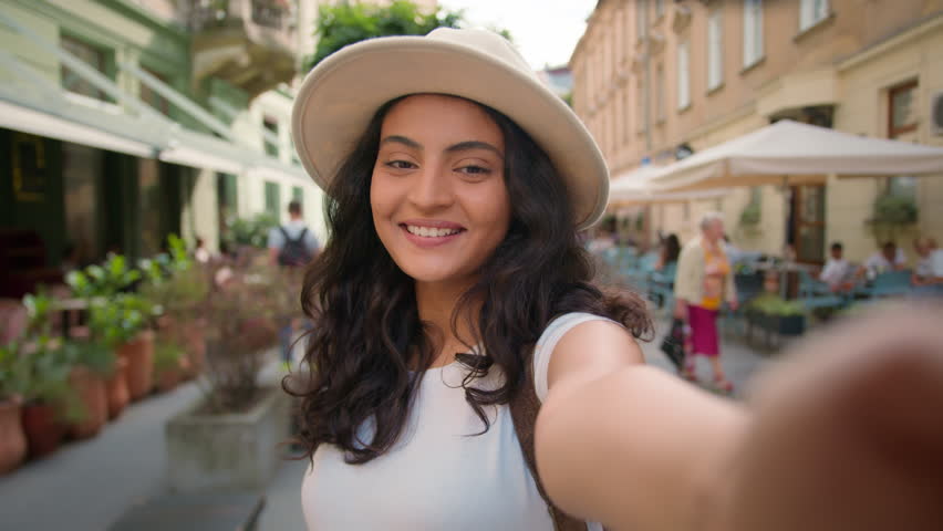 Young happy smiling tourist Indian Arabian lady woman female student waving hand social media vlogger holding smartphone talking camera shooting making online video call virtual mobile outside street Royalty-Free Stock Footage #3454952757