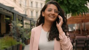 Laughing smiling woman Indian Arabian ethnic happy female girl businesswoman student talking mobile phone call telephone walking city street cafe. Discussion online connection outside travel outdoors - Powered by Shutterstock - Get 15% off with code: PIKWIZARD15