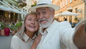 Portrait joyful smiling Caucasian couple elderly mature happy family man husband wife woman posing outside street cafe taking photograph selfie picture mobile phone. Traveling retirement technologies - Powered by Shutterstock - Get 15% off with code: PIKWIZARD15
