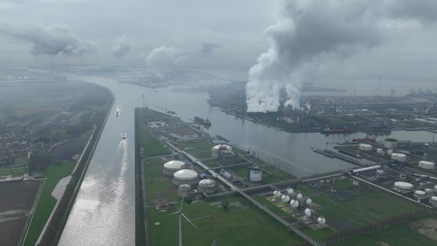 Aerial hyperlapse time lapse of the chemical industry at the port of Antwerp, Belgium. Shipping transport waterways and smoking industry in operation.