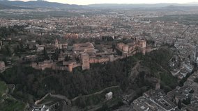 Picturesque aerial video unveils the Alhambra fortress overlooking the town of Granada, Andalusia region south Spain. Panoramic view, flying backwards.