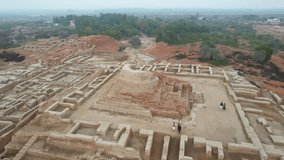 Captivating aerial Video of a Buddhist stupa located in the historic site of Mohenjo Daro, amongst the ancient ruins of the Indus Valley Civilization, with visitors exploring the area.