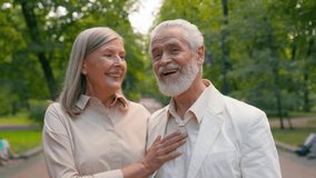 Retired happy smiling Caucasian senior elderly couple family man woman grandma grandpa wife husband talking actively laughing walking together outside park fresh air healthcare relationship retirement - Powered by Shutterstock - Get 15% off with code: PIKWIZARD15
