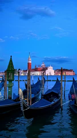 Romantic vacation Venice travel background - gondolas in lagoon of Venice by Saint Mark (San Marco) square with San Giorgio di Maggiore church in background in the evening in Venice, Italy