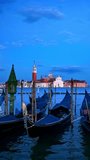Romantic vacation Venice travel background - gondolas in lagoon of Venice by Saint Mark (San Marco) square with San Giorgio di Maggiore church in background in the evening in Venice, Italy