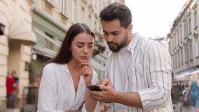 Couple Caucasian man woman using mobile phone smartphone internet maps location tourism trip tour GPS navigation app city center outside street confused male female attractions journey direction urban - Powered by Shutterstock - Get 15% off with code: PIKWIZARD15