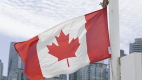 A 4k slow-motion video of a Canadian flag flapping in the wind with the Vancouver, British Columbia skyline in the background.